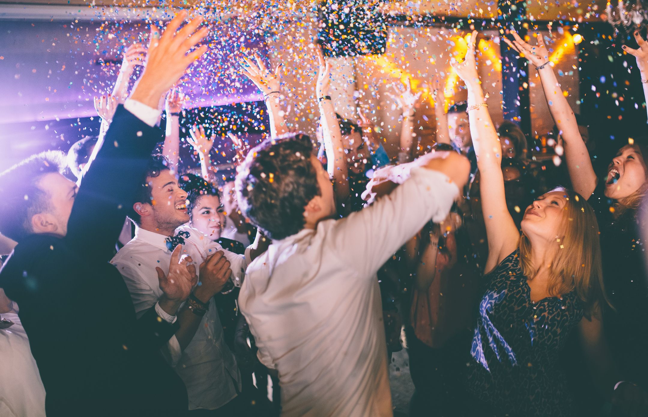 group of hipsters throwing confetti at a party in royalty free image 469322890 1544723219 - Chloe and Daniel's House Music-Inspired Wedding